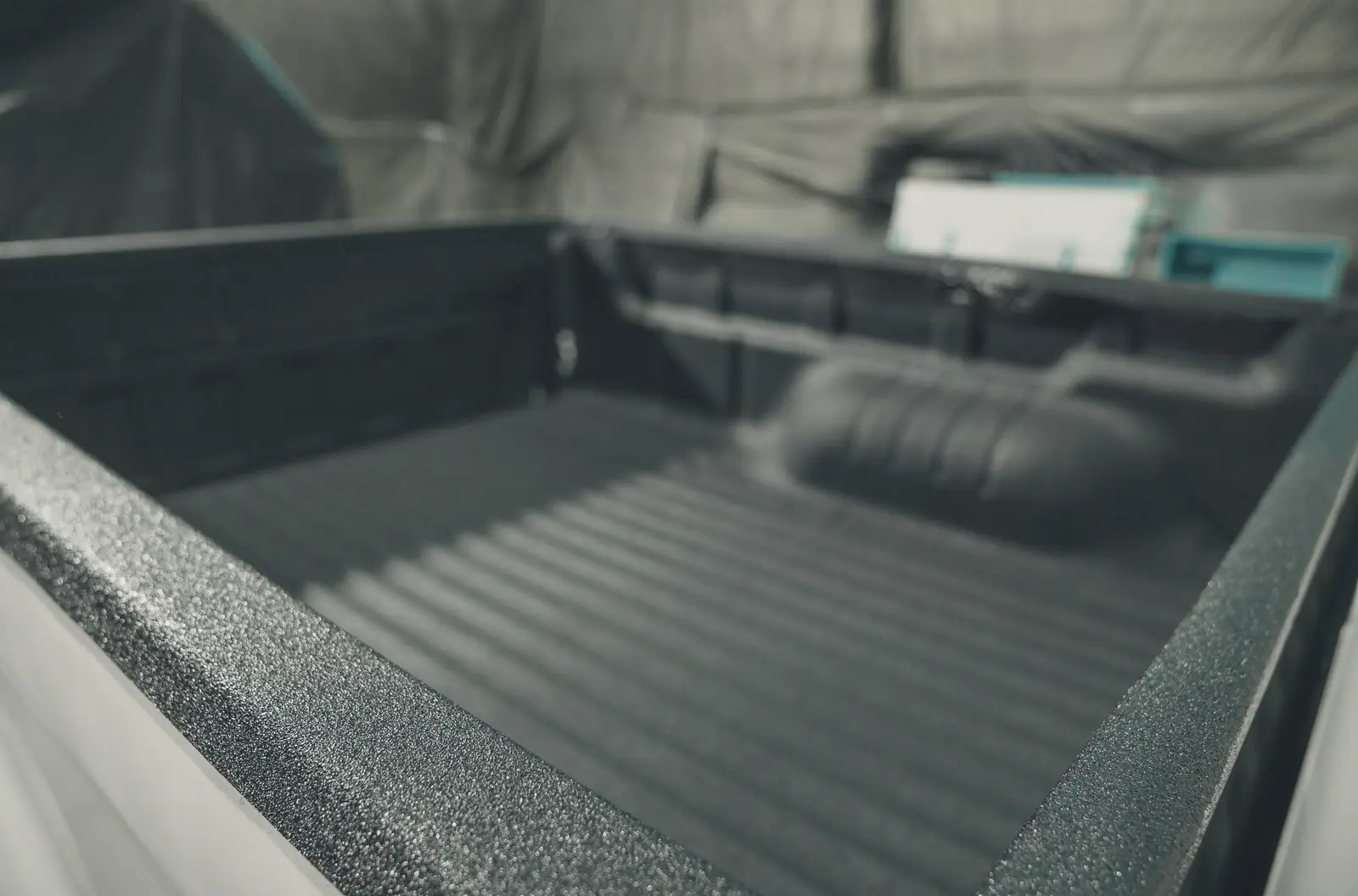 Pickup truck bed finished with a black textured spray liner