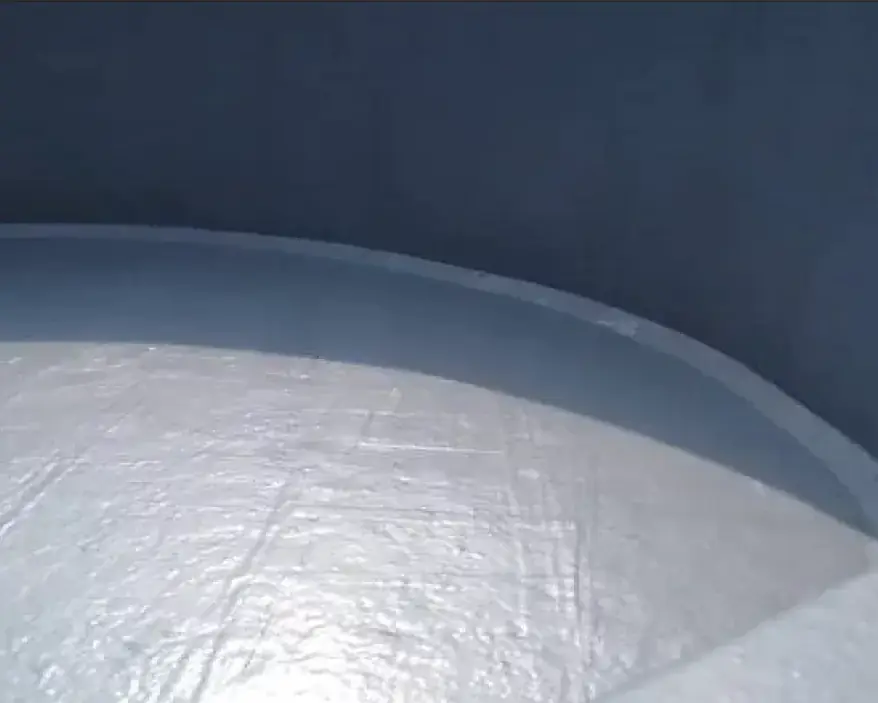 Smooth gray coating lining the inside of a round tank